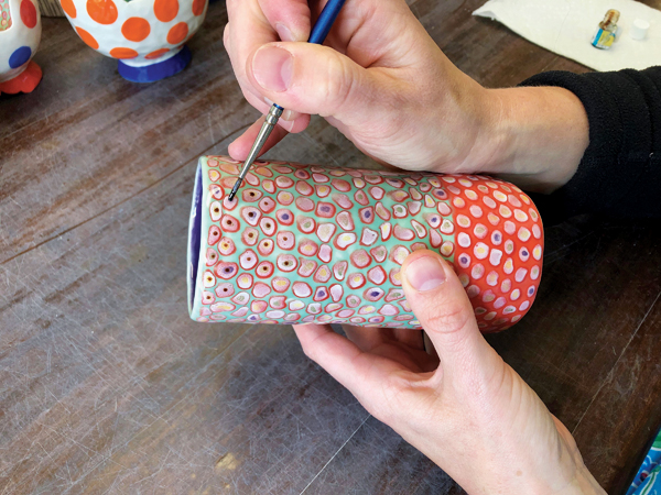 4 Once the pot has been fired, apply gold luster to the center of each dot.