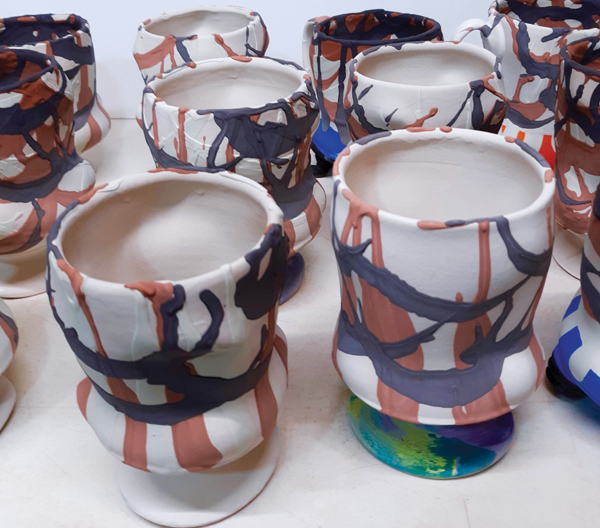 5 Several cups with various colored glazes squirted over the clear glaze.