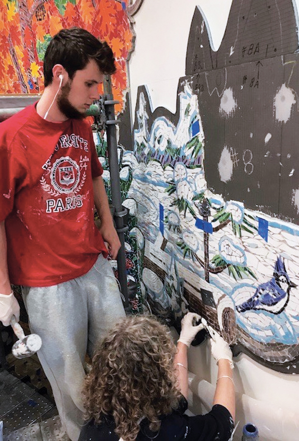 11 Charles Winer and Liane Noddin installing mosaics into cement on the winter section.