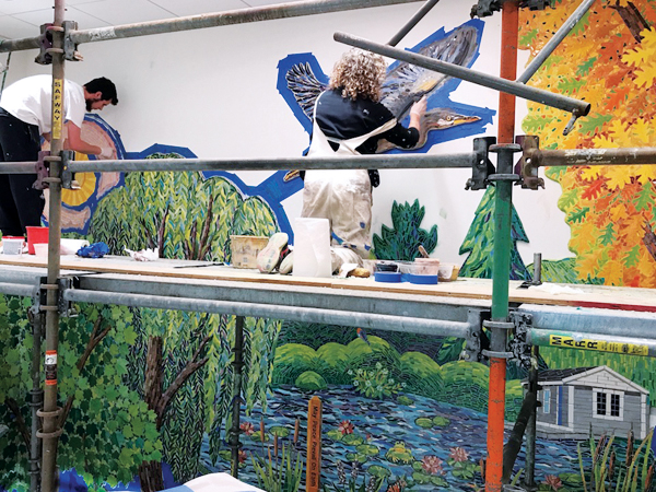 12 Charles Winer and Liane Noddin on the upper level of the scaffolding applying colored grout to the willow tree and heron.