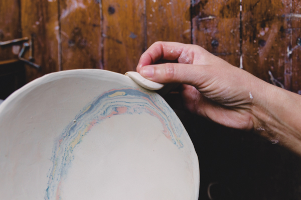 15 Once the bowl is firm enough to take off the hump mold, use a soft sponge to clean up the edges.