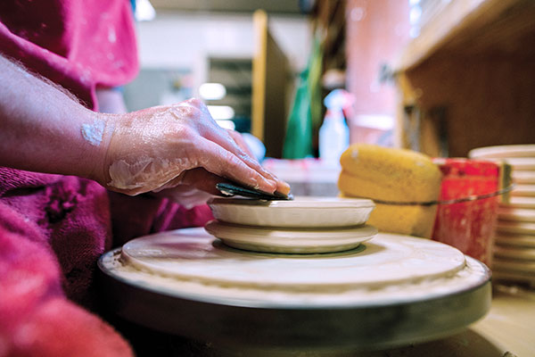 4 Compress a ball of clay with a wooden rib to make a thick saucer. 