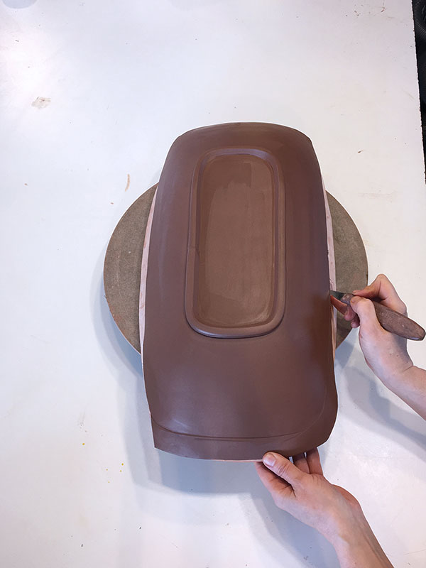 5 Trim excess from the rim of the platter using a fettling knife.