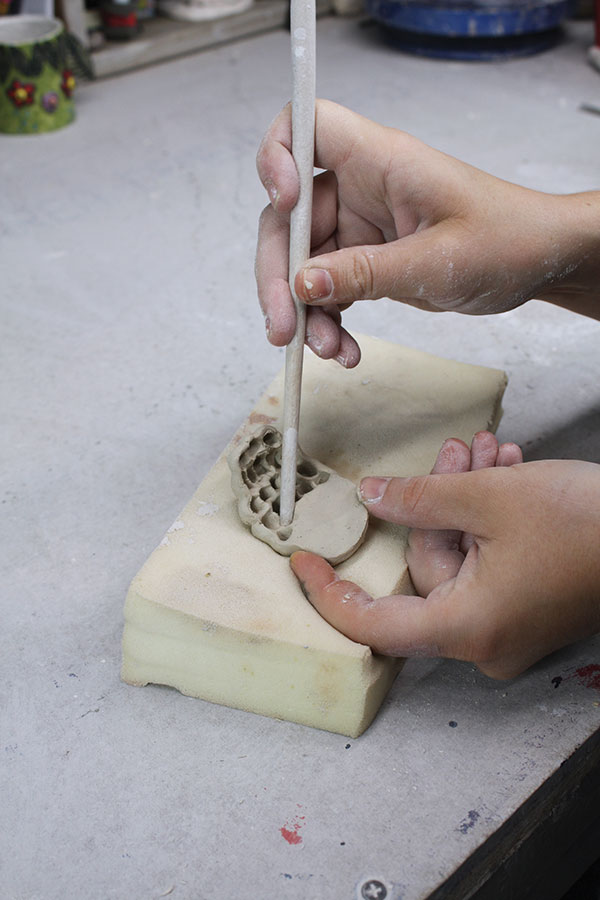 6 Using foam and a wooden paint brush, push out ear puffs in an oval slab.