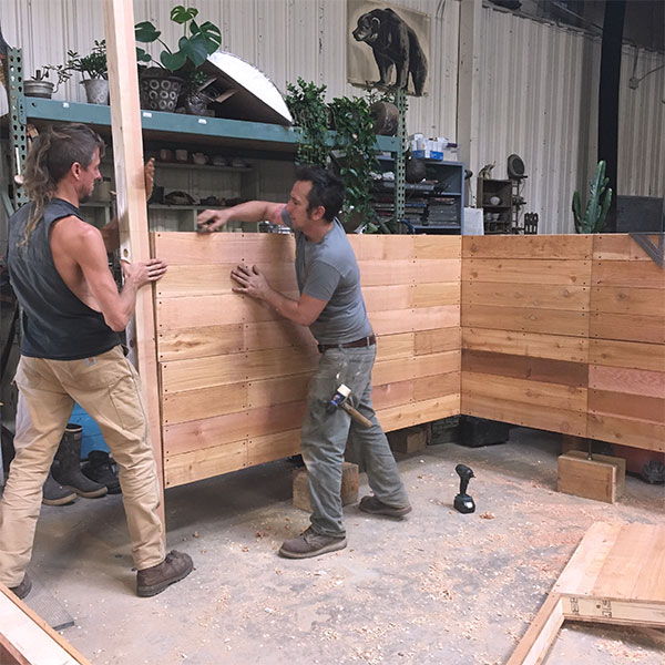 1 Elijah and Matty work to attach the wall panels to the 4×4-inch posts.