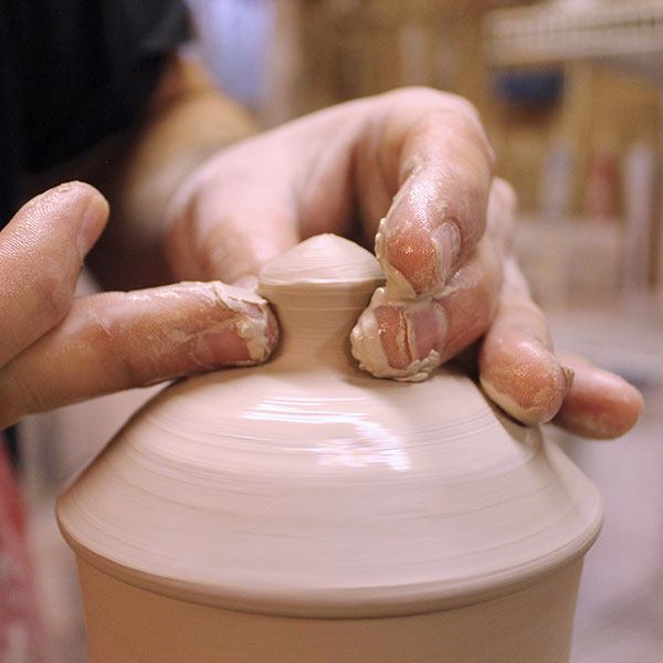 15 Attach a ball of clay to the scored area, then throw a solid knob on top of the lid.