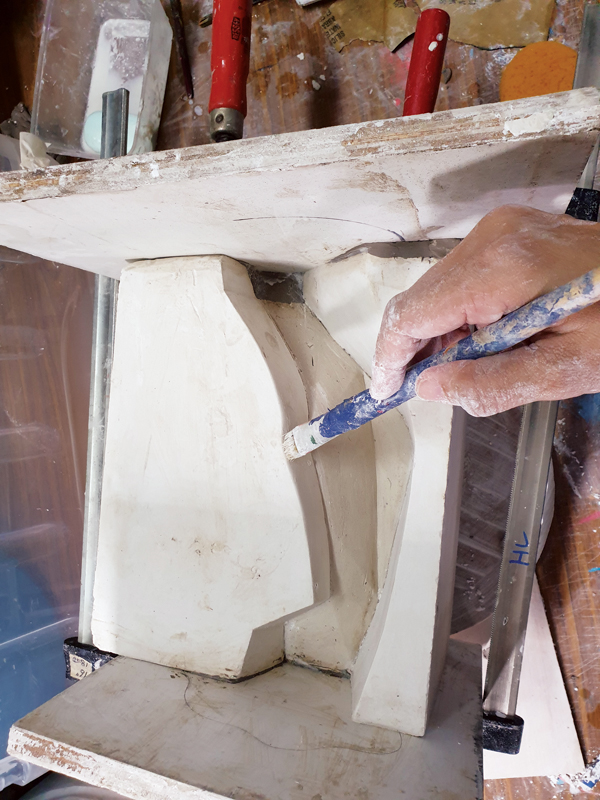 12 After casting the third section, remove the clay partition and turn the mold horizontally to cover the sides. Soap must be brushed on all exposed plaster. Set up the other boards, then pour the fourth part of the mold. 