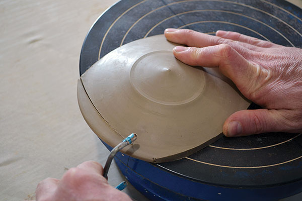 8 Use a wire harp and the edge of the banding wheel to create a square lid.