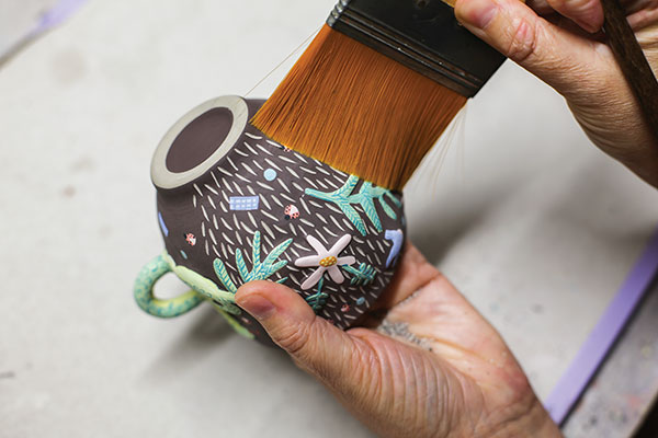 16 Remove debris with a large flat brush to avoid unwanted underglaze marks.