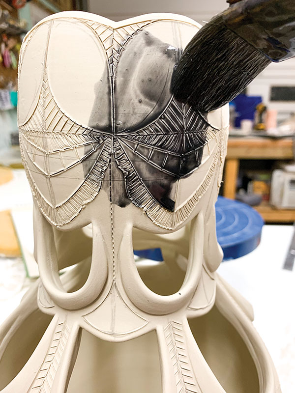 10 Apply thin, watered-down underglaze to the carved lines with a wide brush.