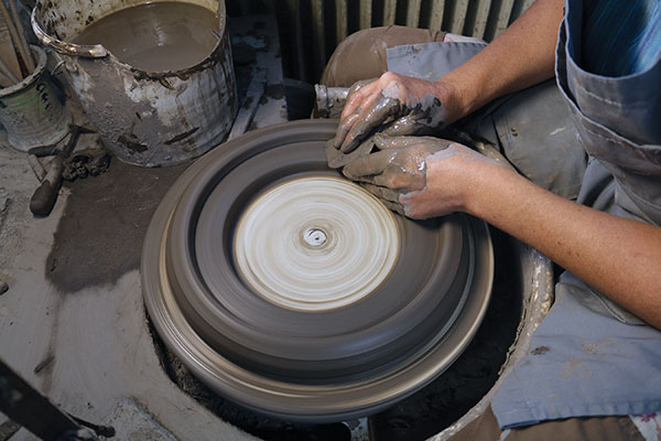 1 Working on a bat, throw the clay into a large ring. Create a lower inner lip by pressing down with a rib.