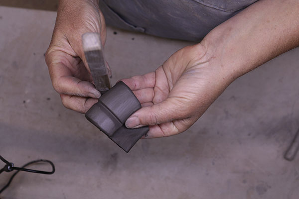 4 Use the edge of a wooden stick to press two indented lines into the piece, from bottom to top. This creates the three toes.