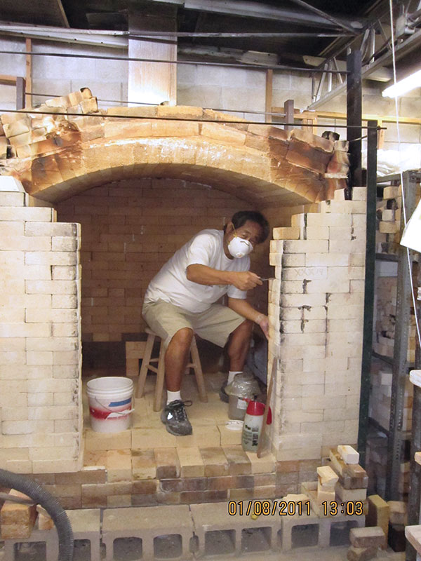 6 Shige Miyamoto building out the front of the kiln to accommodate the new sliding door. 