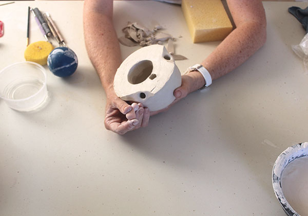 6 Creating the apertures in the body of the form for the ball joints that will link it with the chains after the bisque firing.