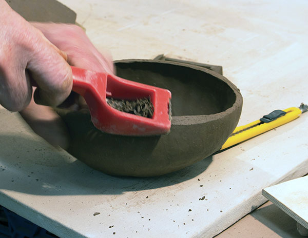 3 Let the oval bowl set up to a soft leather hard. Use a rasp to bevel the top edges.