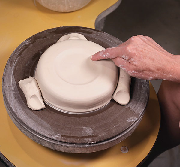 4 Gently press the clay along the ring edge to form an indentation for the cup to sit. 
