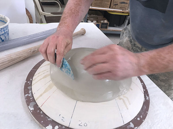 2 Spray water onto the slab, then use a flexible rubber rib to compress and even out the slab. 