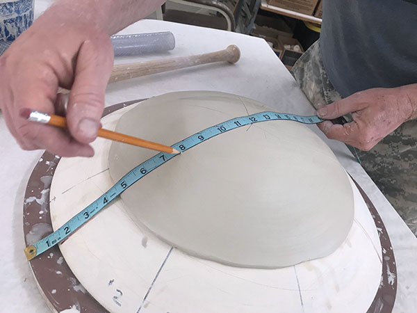 4 Use a flexible tape measure and dividing lines made on the mold to determine the foot’s placement.