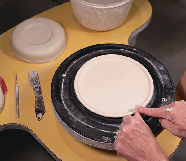 7 With the wheel turning, slide a wet finger under the plate edge to turn it upward. Remove the dome, then smooth the rim.