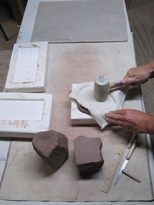 14 Cover the clay with canvas, then tamp it into the mold with a rubber mallet.