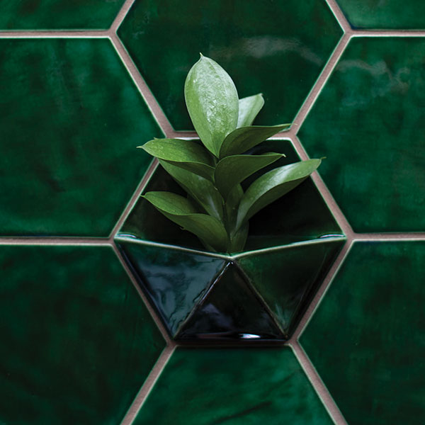 10 Viola! The finished tile with a deep green glaze, installed alongside standard large hexagonal tiles.
