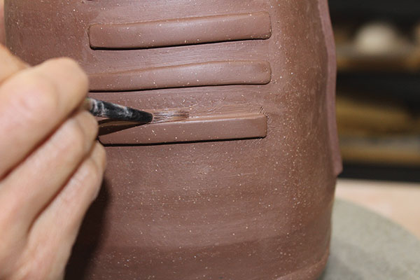 9 Use a paintbrush to smooth score marks after adding the sprigs.