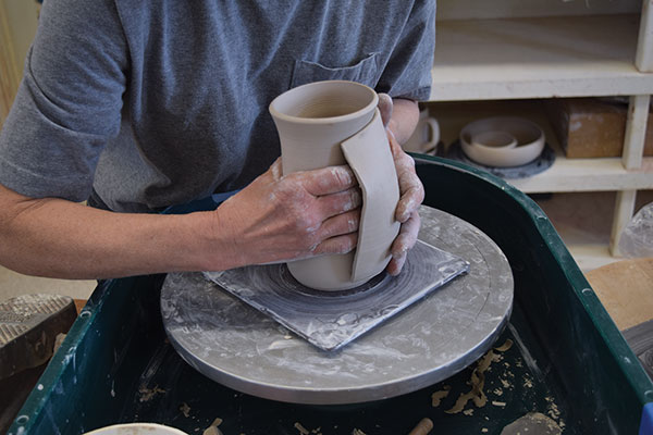 7 Place the pocket on the mug around your hand. Squeeze to create indentations.