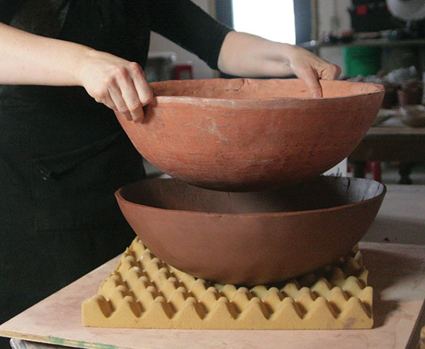 7 Gently pull the bisque mold up from the soft leather-hard clay form.