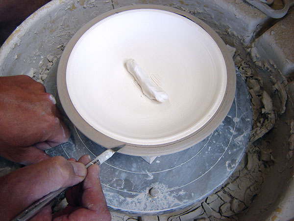 14 With the bisque mold still in place, refine the rim of the bowl.