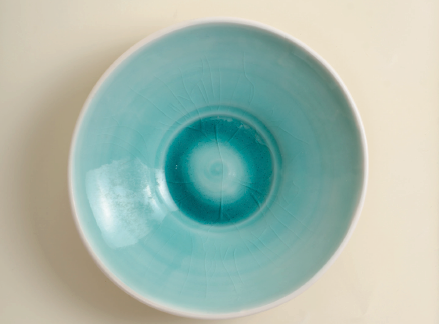 Linda Bloomfield, porcelain bowl with runny turquoise glaze, fired to cone 8. The crazing was caused by a change in the feldspar composition.