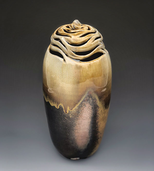 2 Lynn Anne Verbeck’s tall pierced vase, 11 1/4 in. (29 cm) in height, wheel-thrown and altered stoneware, natural ash, sprayed glaze (Unzicker Brothers’ tenmoku sprayed heavier at the top shoulder, then nuka sprayed on the top third), fired in Jack Troy’s Pixiegama kiln, spring 2020. 