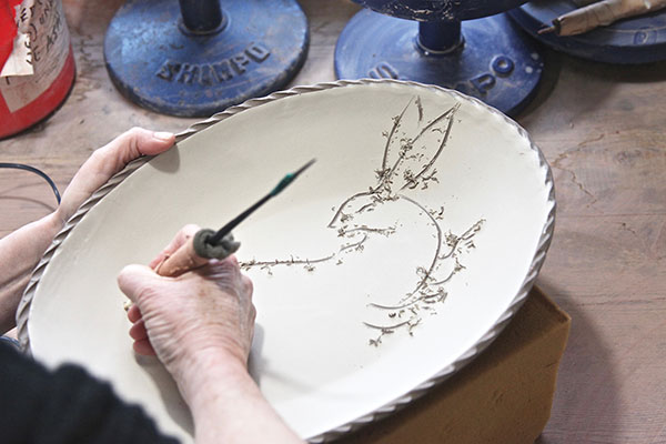 5 Once the surface of the platter reaches leather hard, use a tool to draw directly into the slip.