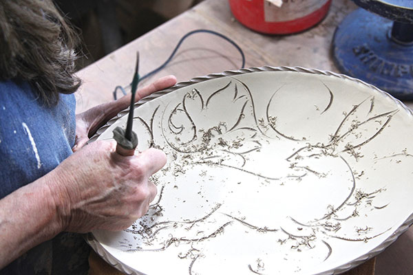 5 Once the surface of the platter reaches leather hard, use a tool to draw directly into the slip.