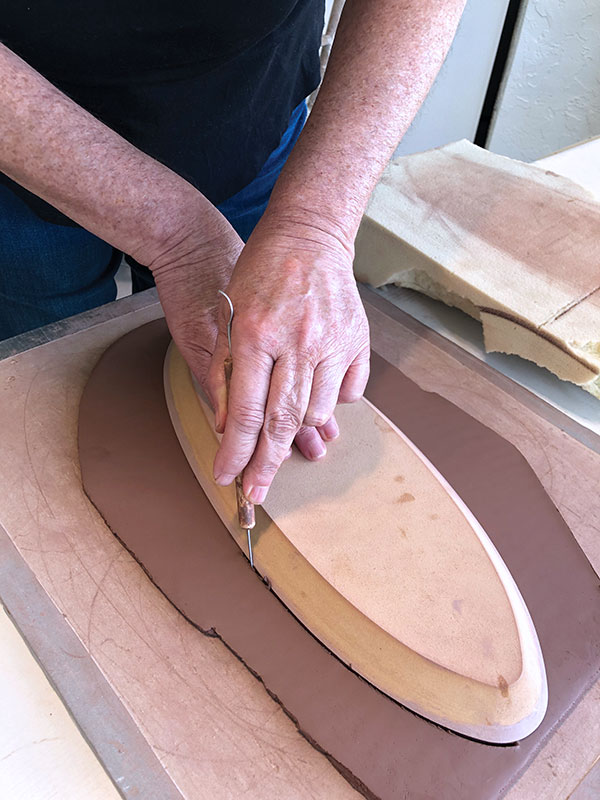 1 Cut out a platter shape using a wooden form and a needle tool.
