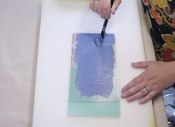 6 Decorate the top of the tray with thick slip by painting over the two stencils. 