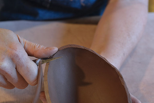 5 Use a sharp knife to remove the top edge of the form, then shape the rim.