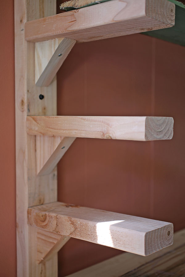 1 Arm-braces for supporting shelves made with 11½-inch lengths of 2×4 boards are placed every 7½ inches vertically.