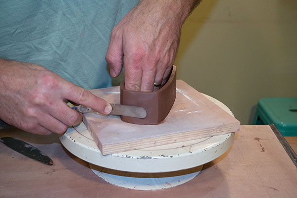 2 Define each of the corners by running a metal rib or spatula from the bottom to the top of the form on all four sides.