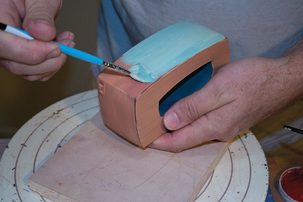 11 Add a layer of turquoise underglaze to the leather-hard salt cellar. A contrasting layer of orange underglaze was applied first.