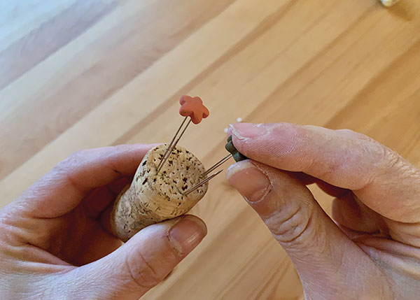 3 Carefully press leather-hard pieces onto the pin sets.