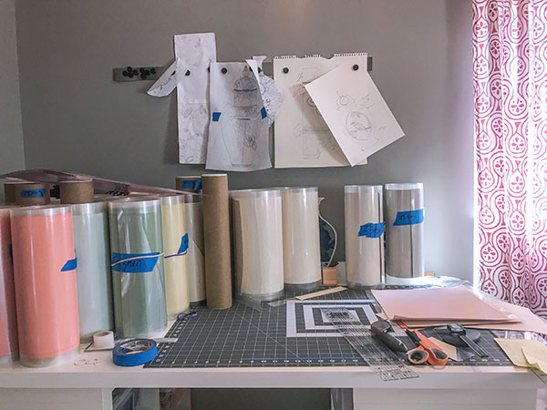 B Studio work table; the rolls are pliable ceramic sheets ready to be cut. Long sheets of porcelain are cut down to size using a cutting mat and fabric roller cutter.