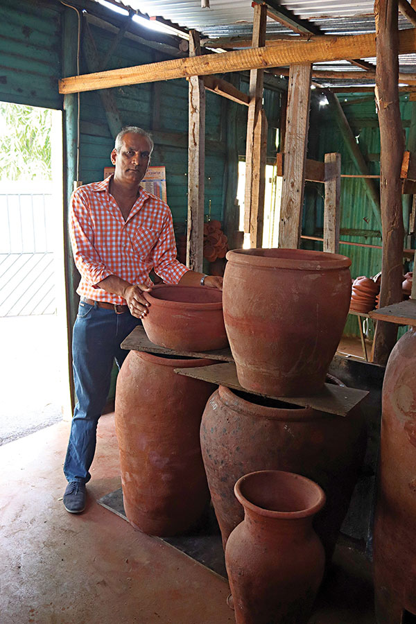 1 Biswajeet Ramlochund (Ram) with large pots in the National Pottery showroom. 