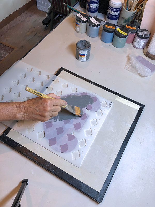 3 Using a large stiff brush, apply slip through the stencil.