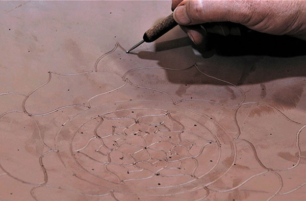 4 Use a ball stylus to draw the lotus-flower design, using the points delineating the sections as a guide.