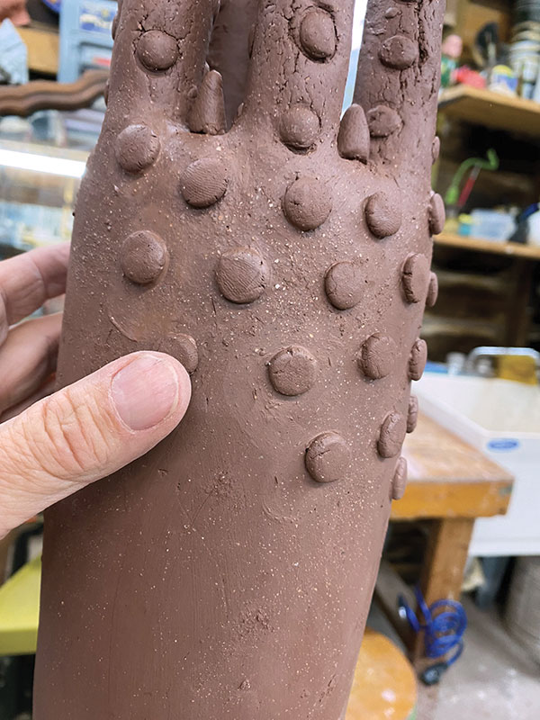 13 Form small balls of clay into dots. Score and slip them onto the surface of the larger form. Dry and bisque fire the piece.