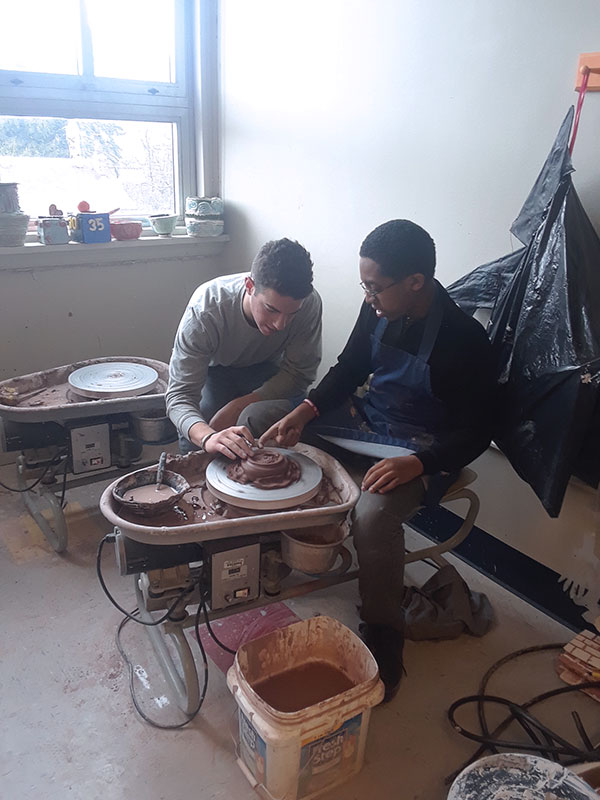 9 2018 Clay Sibling Saul Bezner showing a student how to trim a bowl. Westinghouse Academy, Pittsburgh, Pennsylvania.