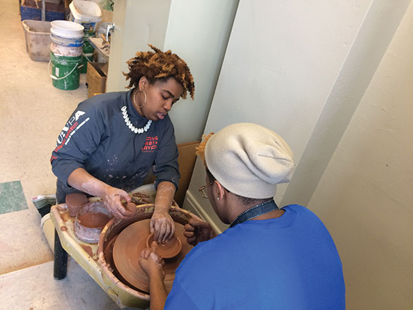 6 2018 Clay Sibling Gerald A. Brown showing a Westinghouse Academy student how to pull and open a bowl.