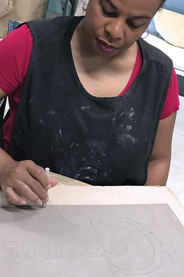 6 Jessica Colebrooke working on a house name tile, low-fire stoneware, 2020. Photo: Erin Colebrooke.