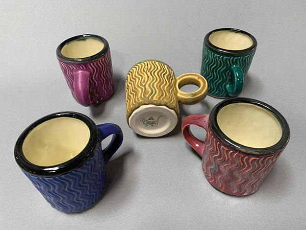 Jonathan Kaplan’s textured coffee cups, 3 1/2 in. (9 cm) in height, slip-cast whiteware, fired to cone 5, ceramic decals.