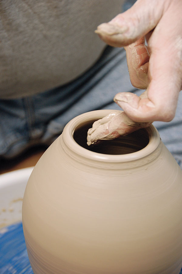 9 The neck and rim of the bottle form will become thicker after collaring the clay. Pull the wall up higher to thin it out again.